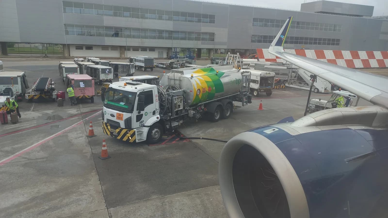 Caminhão abastece avião com querosene de aviação em pátio de aeroporto