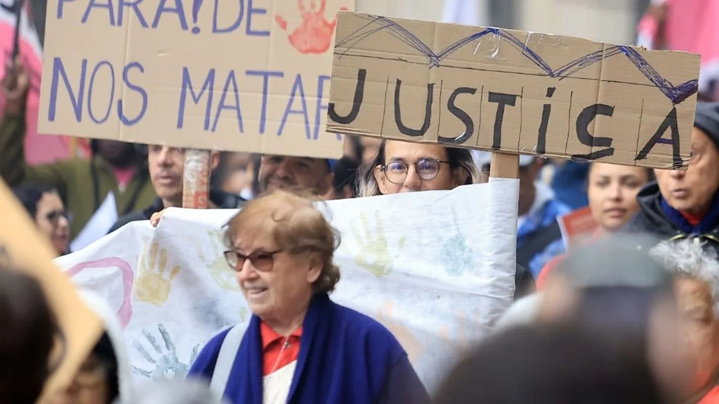 Manifestantes seguram cartazes escritos 'Pare de nos matar' e 'Justiça' durante ato do Grito dos Excluídos