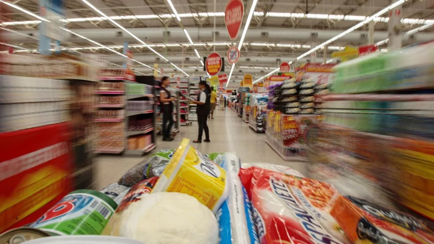 Consumidor em corredor de supermercado, imagem ilustrativa sobre inflação e poder de compra