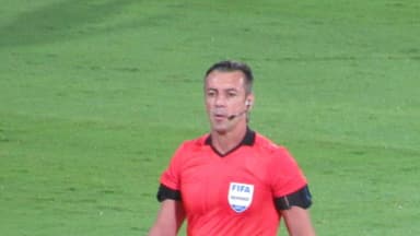 Árbitro de futebol com uniforme da FIFA em campo