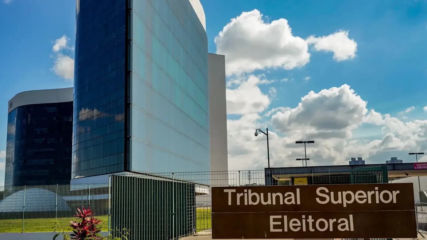 Fachada e placa do Tribunal Superior Eleitoral (TSE) em Brasília, com céu azul e nuvens ao fundo