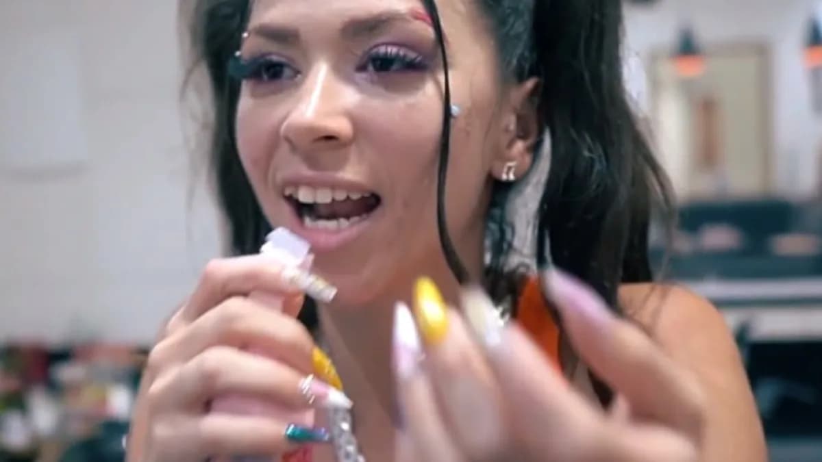 MC Pipokinha sorri segurando um produto de beleza em vídeo de bastidor