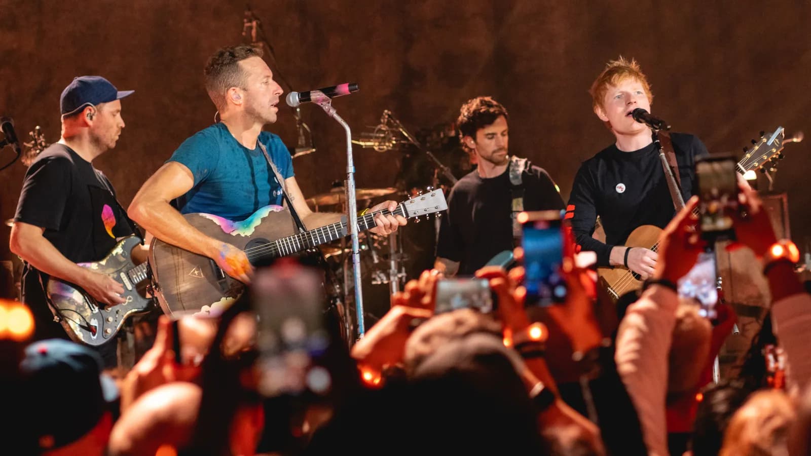 Ed Sheeran toca violão ao lado de integrantes do Coldplay durante show