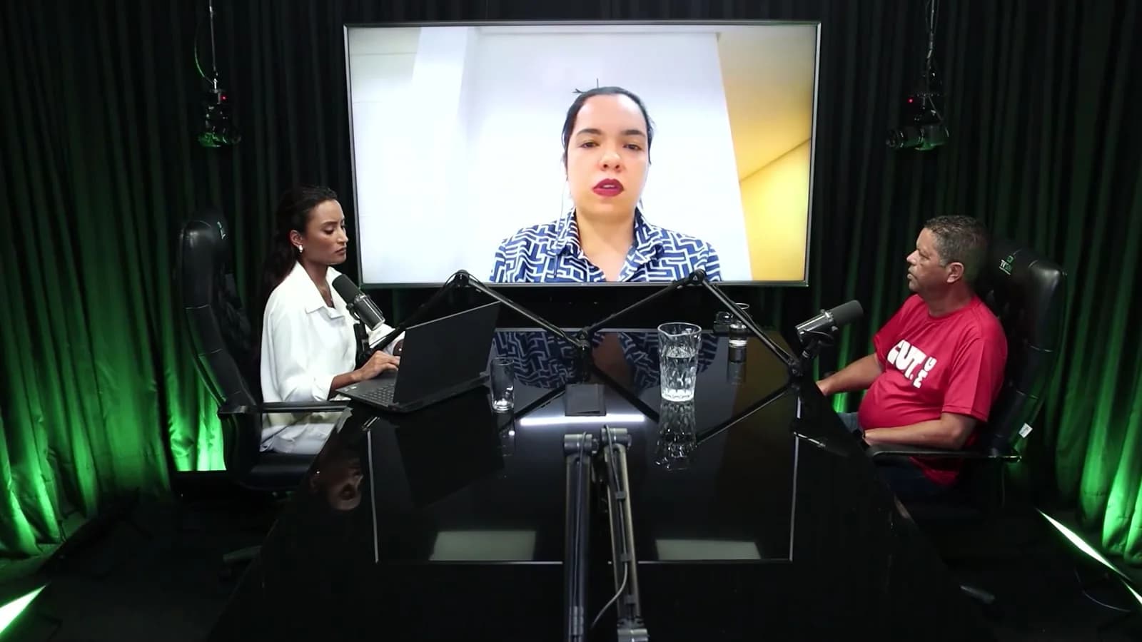 Gabriela Martins, economista da Fecomércio-MG, participa do debate por videochamada exibida em telão, com a apresentadora e o sindicalista Jairon Nogueira Filho no estúdio da TV Sim Brasil.
