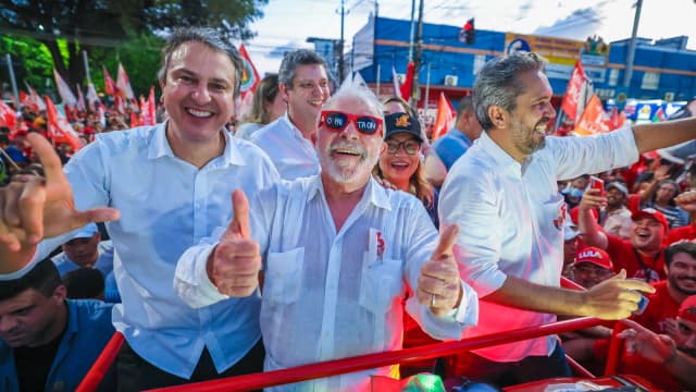 Lula sorri usando óculos escuros em caminhada de campanha cercado por apoiadores em Fortaleza
