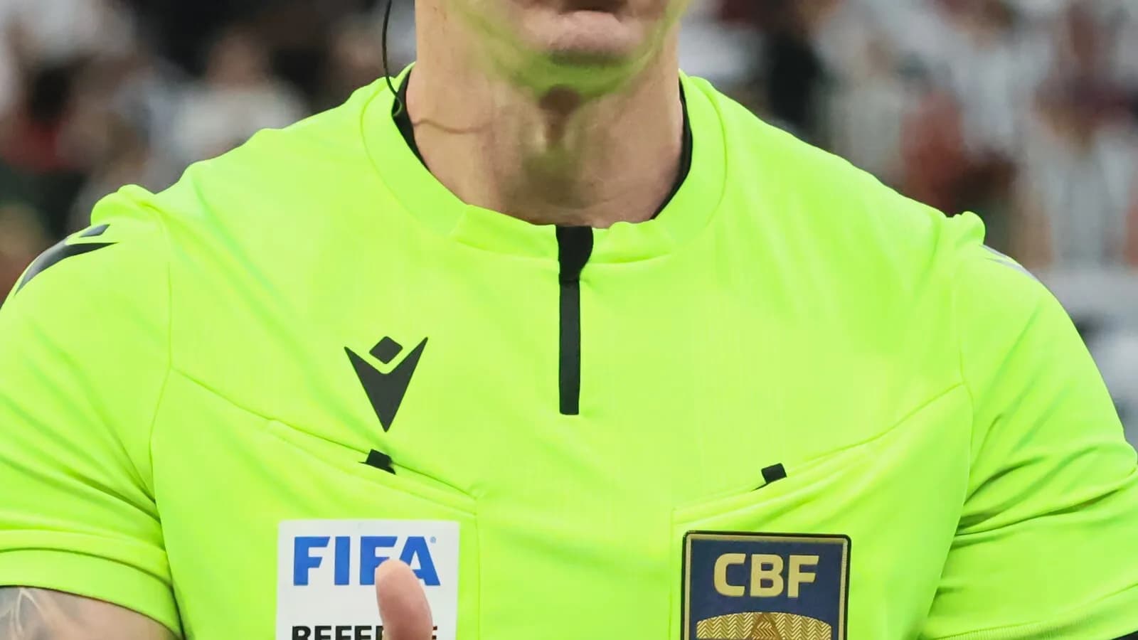 O árbitro Anderson Daronco, de uniforme verde, gesticula durante partida de futebol