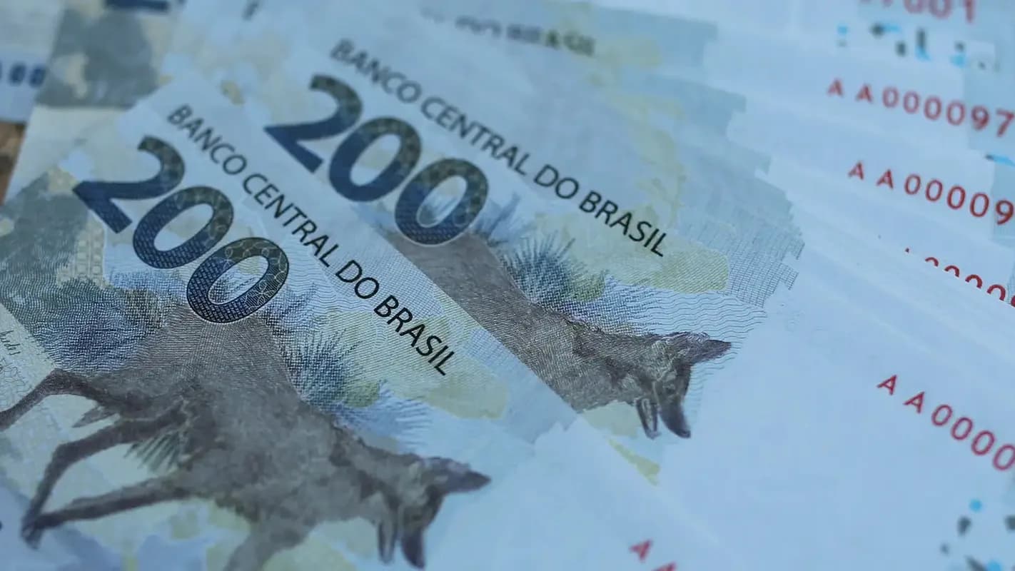 Notas de reais do Banco Central do Brasil espalhadas, com destaque para a nota de R$ 200