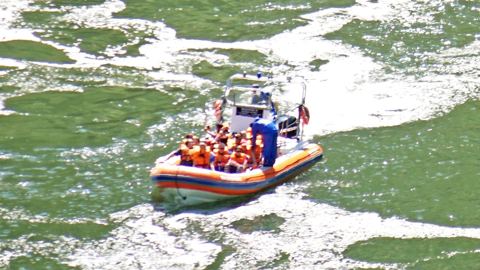 Foto de arquivo de um bote inflável com turistas de colete salva-vidas laranja navegando pelo rio Iguaçu, dentro do Parque Nacional do Iguaçu