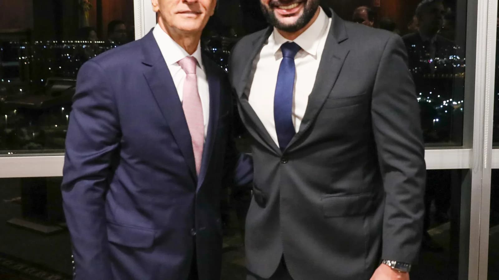 O ministro Marco Aurélio Bellizze, do TSE, ao lado de outro homem de terno, em evento noturno