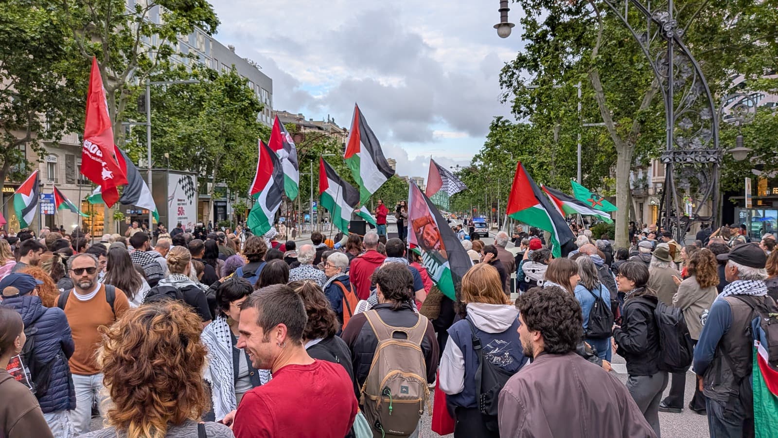 Manifestantes seguram bandeiras da Palestina em ato de apoio à Flotilha Global Sumud em Barcelona