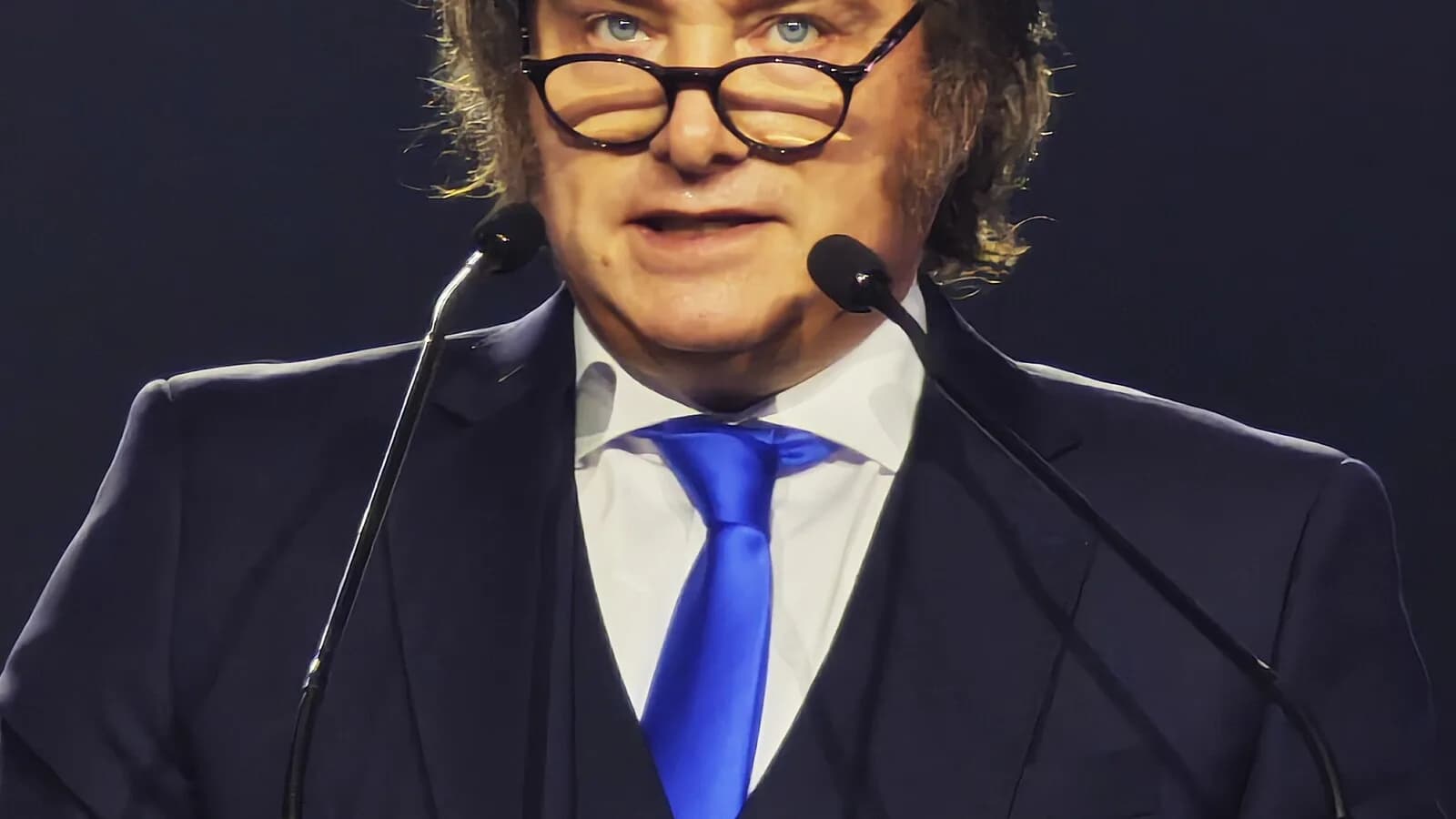 Javier Milei discursa em evento internacional, diante de microfones