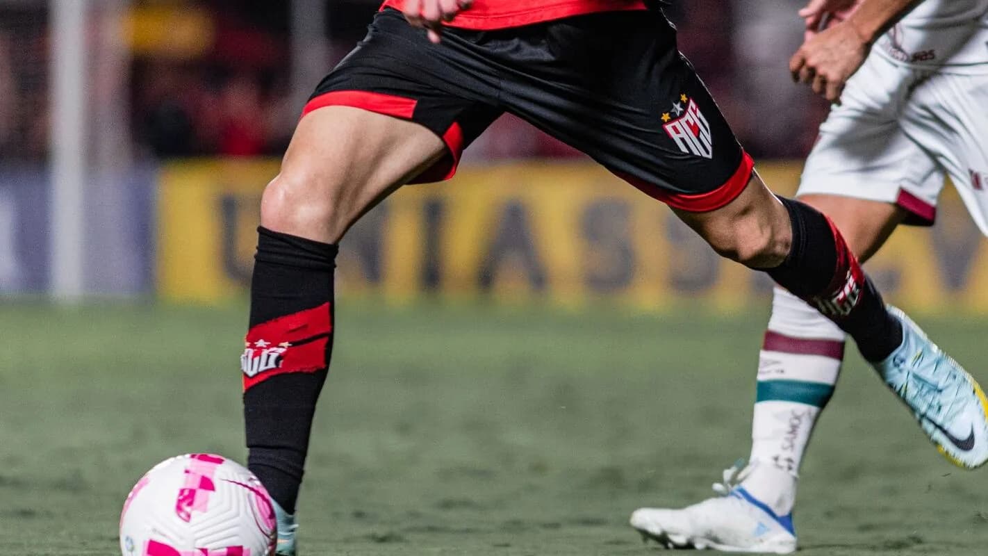 Jogador do Atlético-GO com a bola em disputa contra adversário do Fluminense em jogo de arquivo