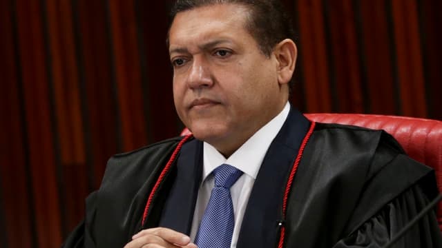 O ministro Kassio Nunes Marques, de toga preta com cordão vermelho, sentado em sessão no plenário do Tribunal Superior Eleitoral, em foto de arquivo