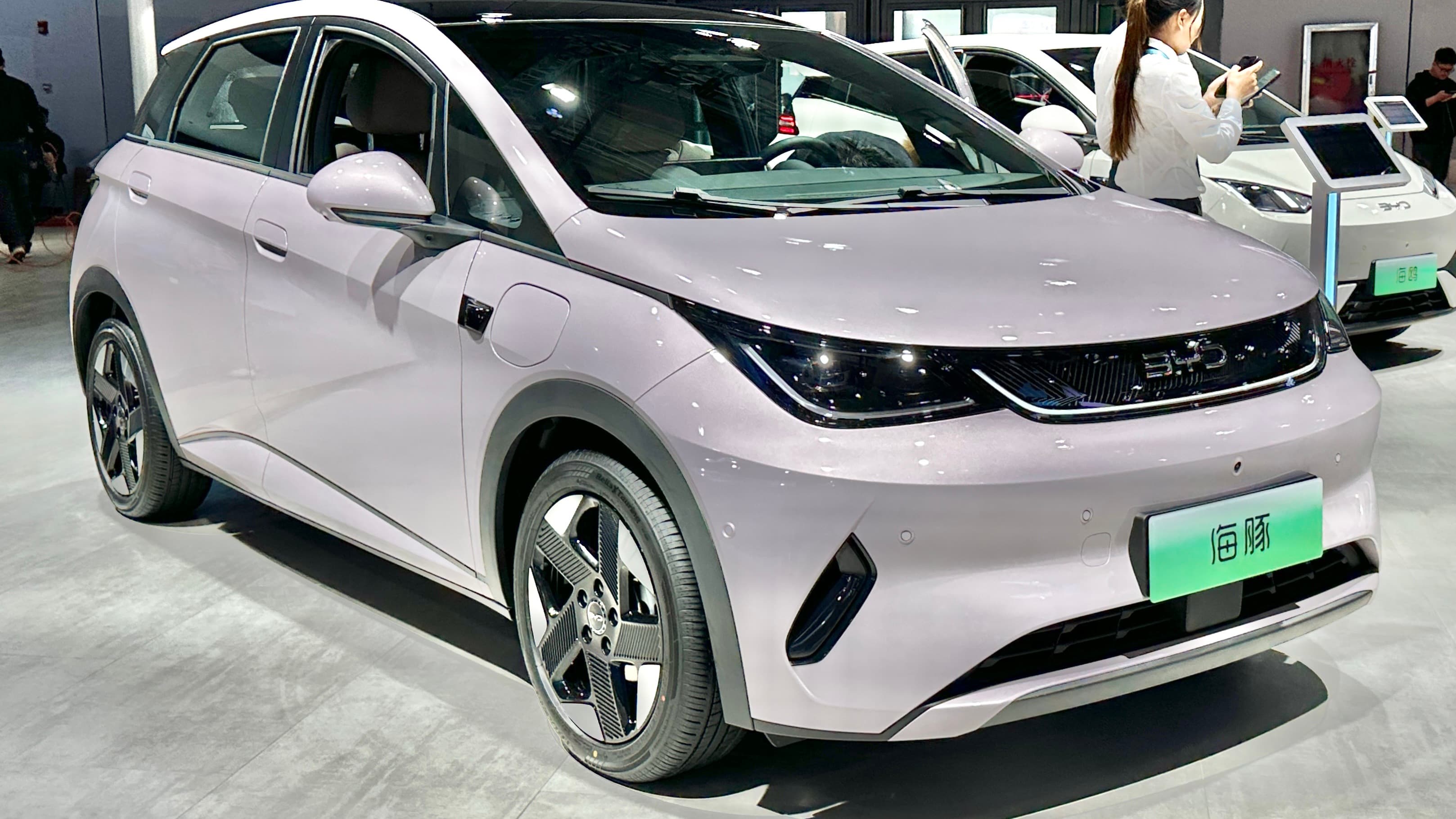 BYD Dolphin exposto em salão automotivo, carro elétrico na cor lilás visto de frente