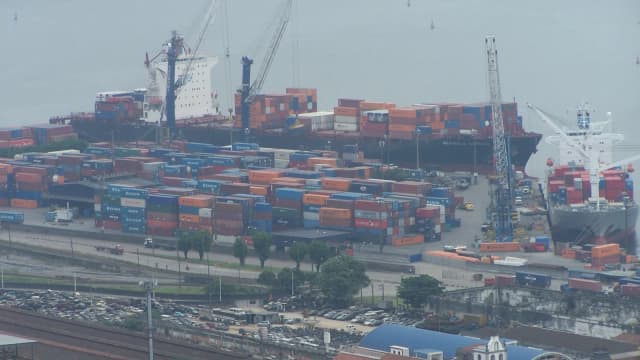 Vista aérea do Porto de Santos com navios porta-contêineres e pátio de cargas