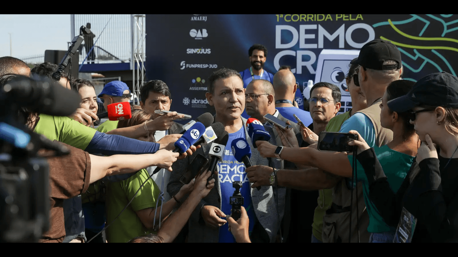 Ministro Kássio Nunes Marques, presidente do TSE, cercado de microfones ao falar com jornalistas em evento público