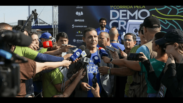 Ministro Kássio Nunes Marques, presidente do TSE, cercado de microfones ao falar com jornalistas em evento público