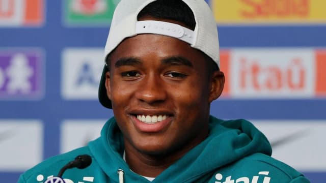 Endrick sorri durante entrevista com uniforme da seleção brasileira