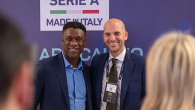 Clarence Seedorf sorri ao lado de outro homem em evento de futebol, foto de arquivo