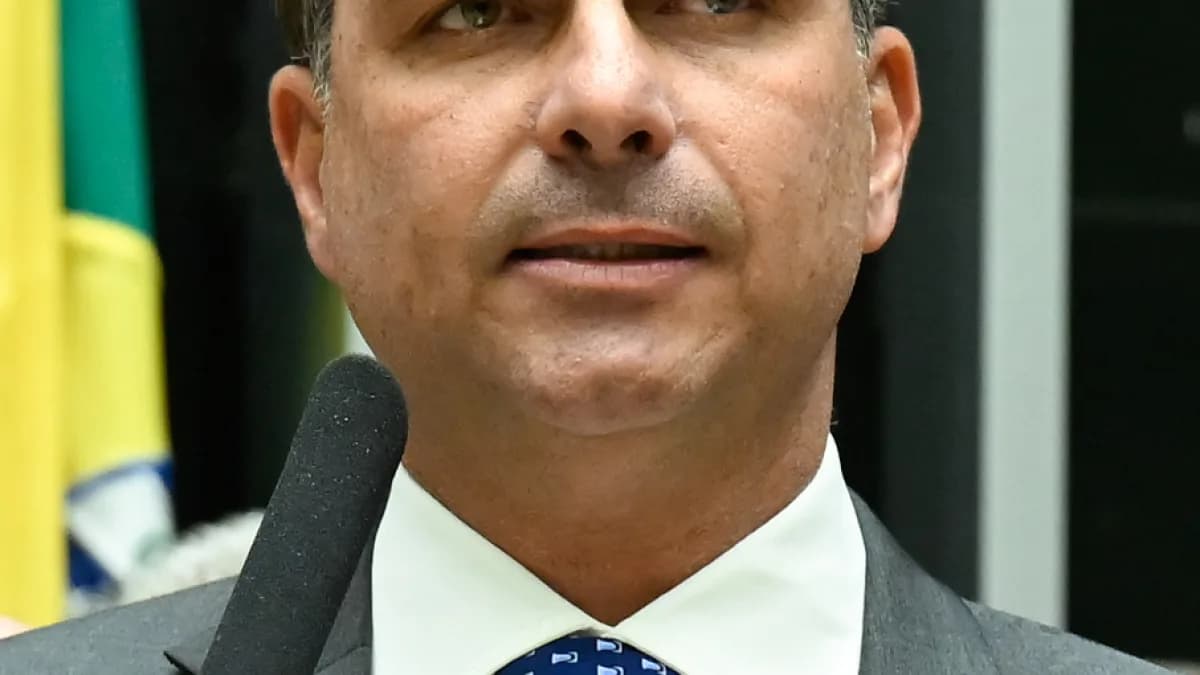 Senador Flávio Bolsonaro discursa em plenário com bandeira do Brasil ao fundo