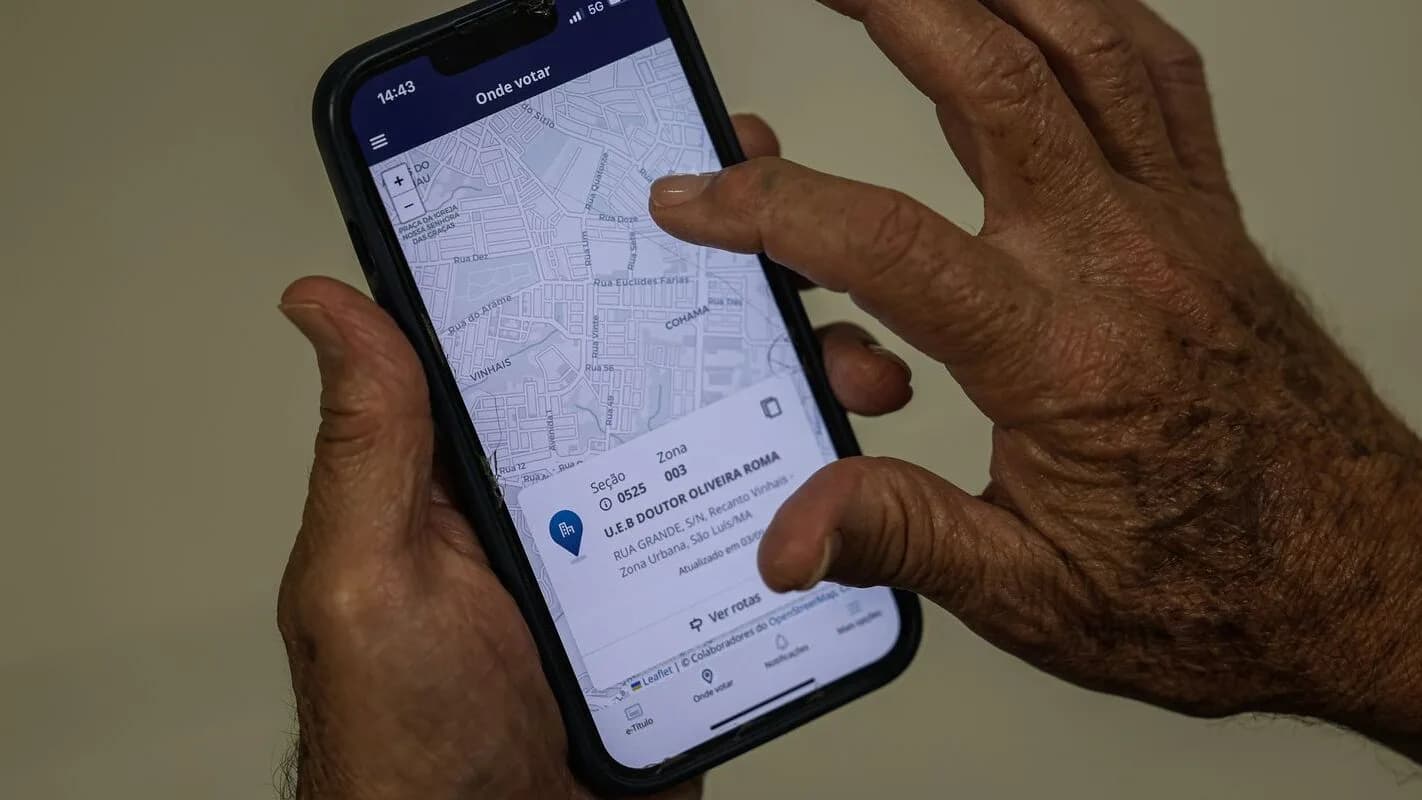 Homem consulta local de votação em aplicativo de celular