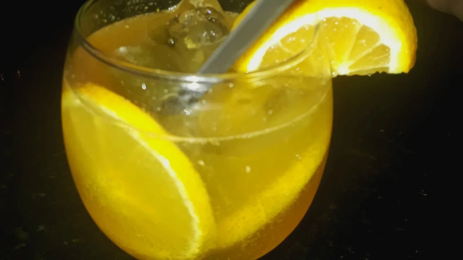 Taça de coquetel amarelo com fatia de limão e canudo