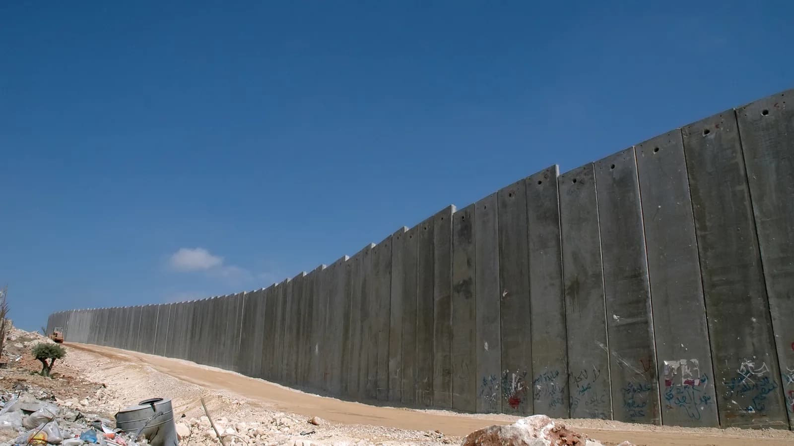 Barreira de separação israelense na Cisjordânia, muro de concreto alto ao longo de uma estrada