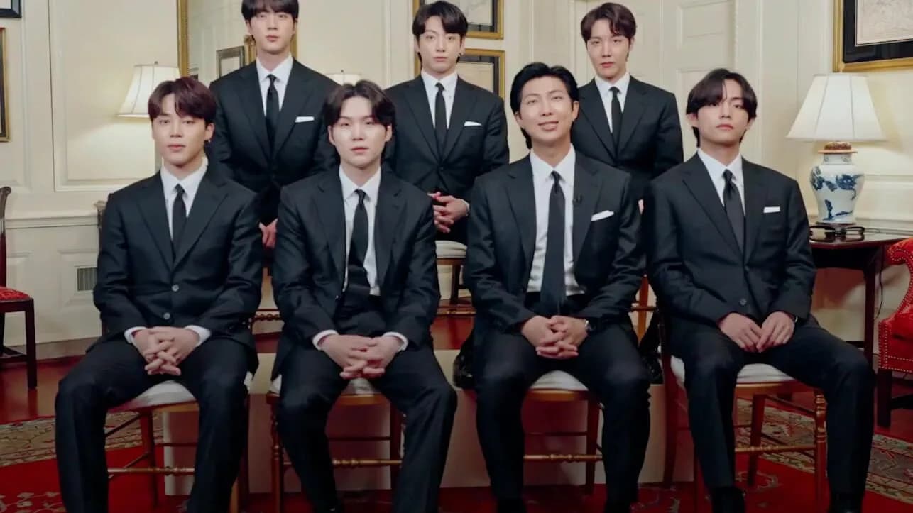 Os sete integrantes do BTS posam juntos, de terno escuro, em foto de arquivo de 2022