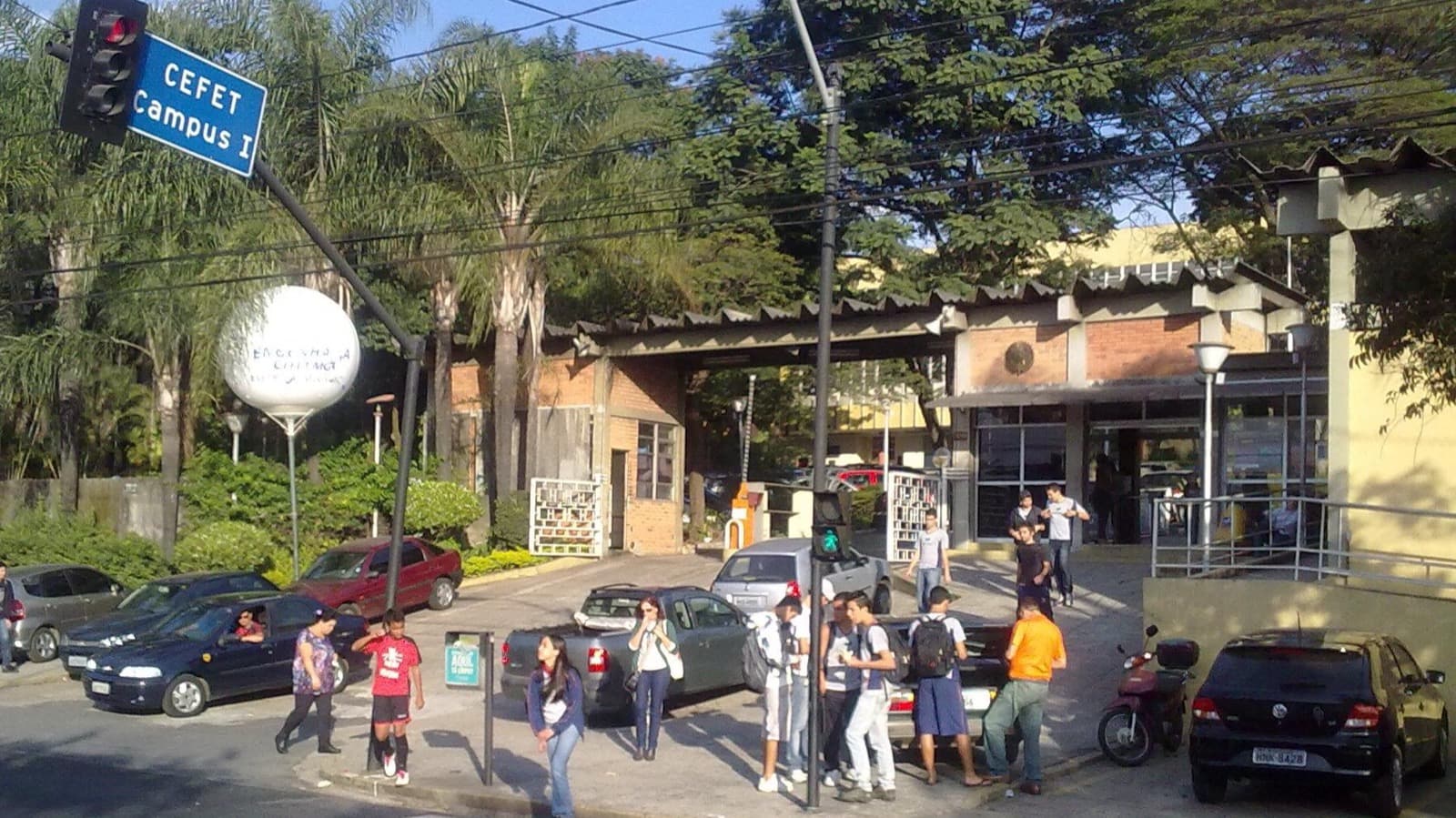 Imagem de arquivo da entrada do campus I do Cefet-MG, em Belo Horizonte, com a placa "CEFET Campus I" e estudantes na calçada