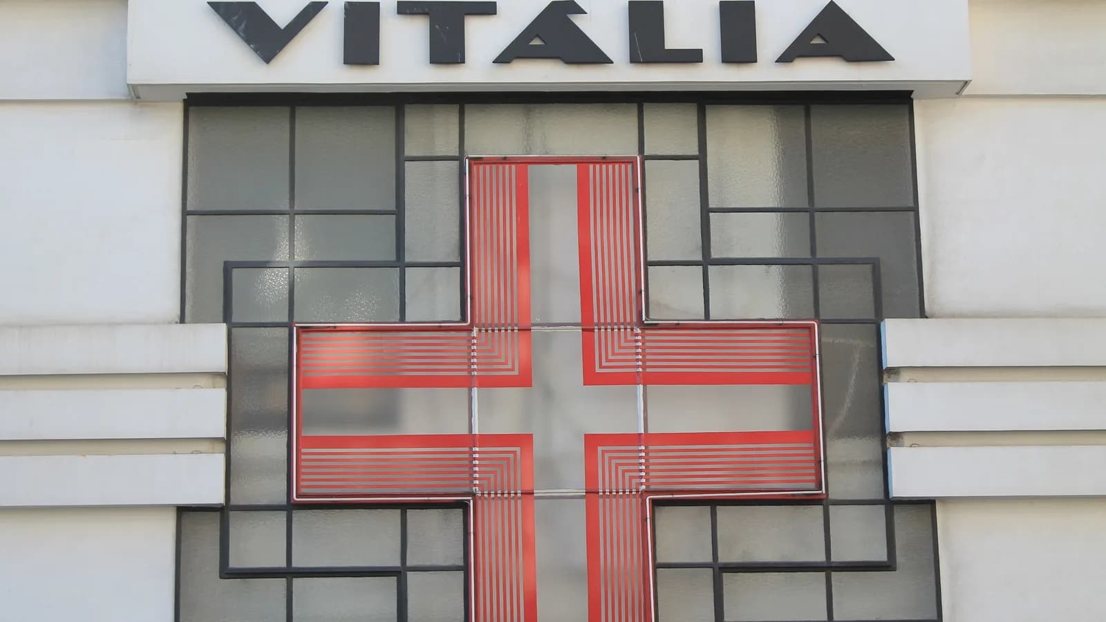 Fachada de farmácia com cruz vermelha, foto ilustrativa sobre o setor farmacêutico