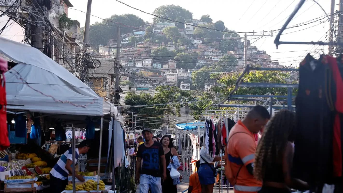 Comércio de rua com barracas e vendedores ambulantes em ladeira de comunidade