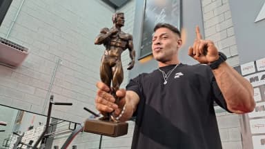 Ramon Dino segura troféu do Mr. Olympia em academia