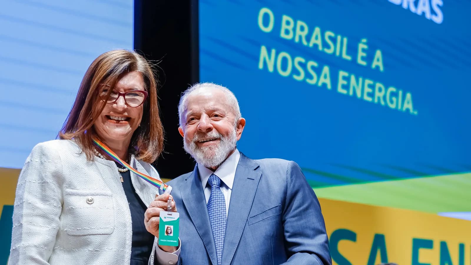Magda Chambriard, presidente da Petrobras, ao lado do presidente Lula em evento com telão dizendo 'O Brasil é a nossa energia'