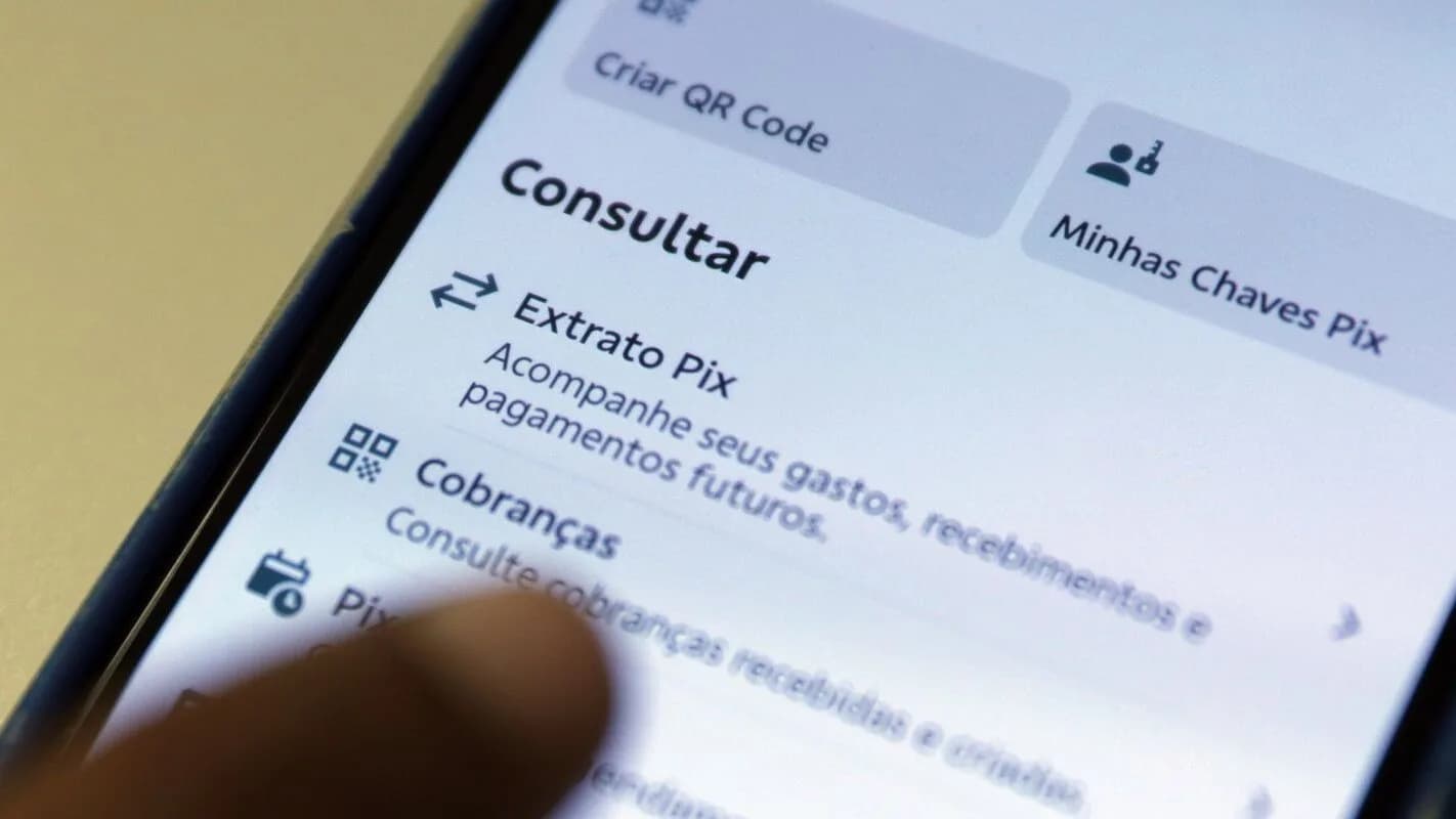 Pessoa segura celular exibindo aplicativo do Pix, usado para pagamentos e apostas online