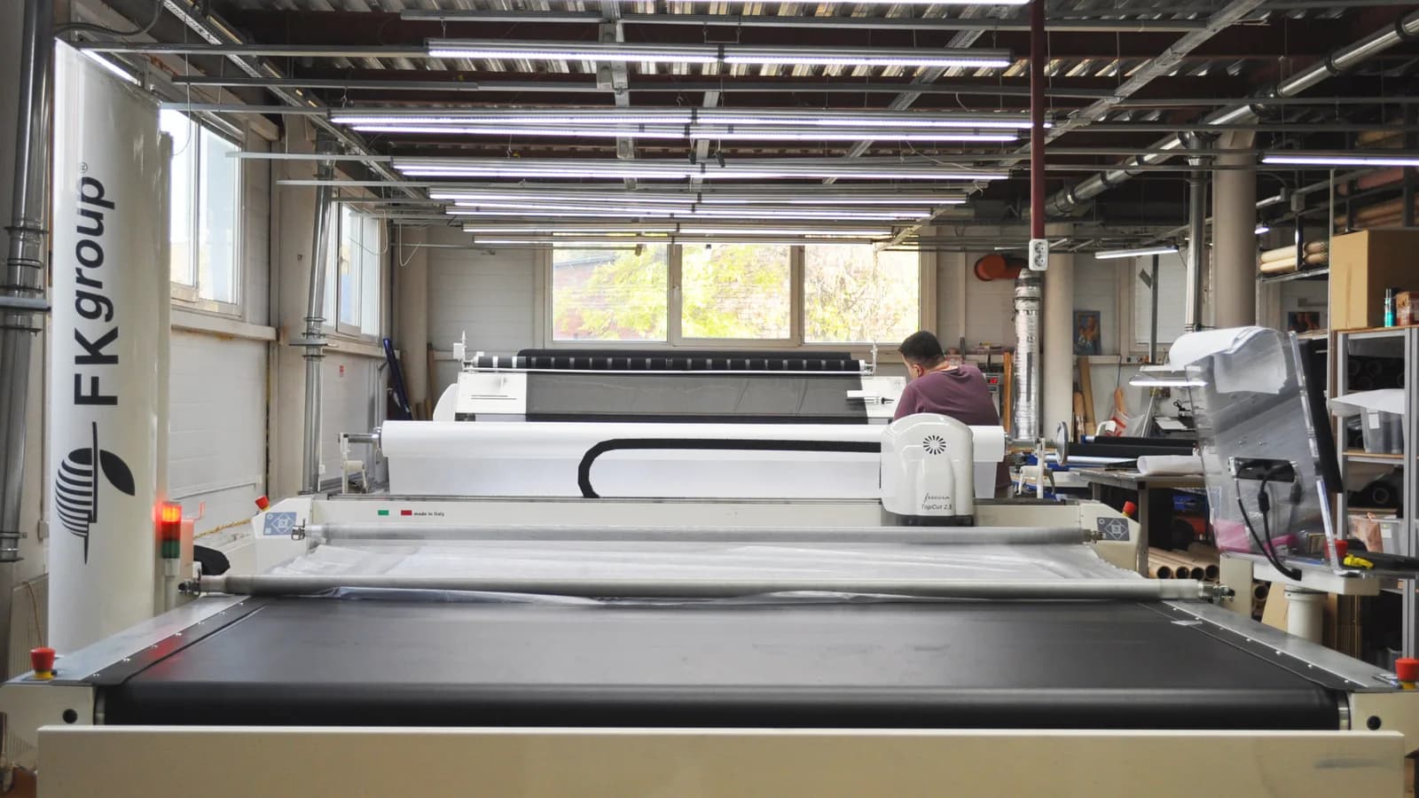 Chão de fábrica com máquina industrial de corte em operação