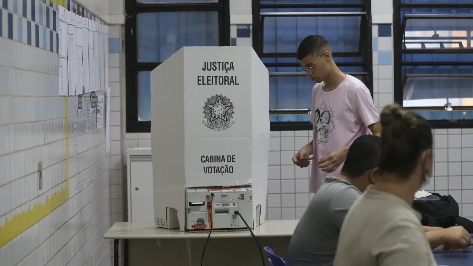 Cabina de votação da Justiça Eleitoral com eleitor se aproximando da urna (imagem de arquivo de eleição anterior)