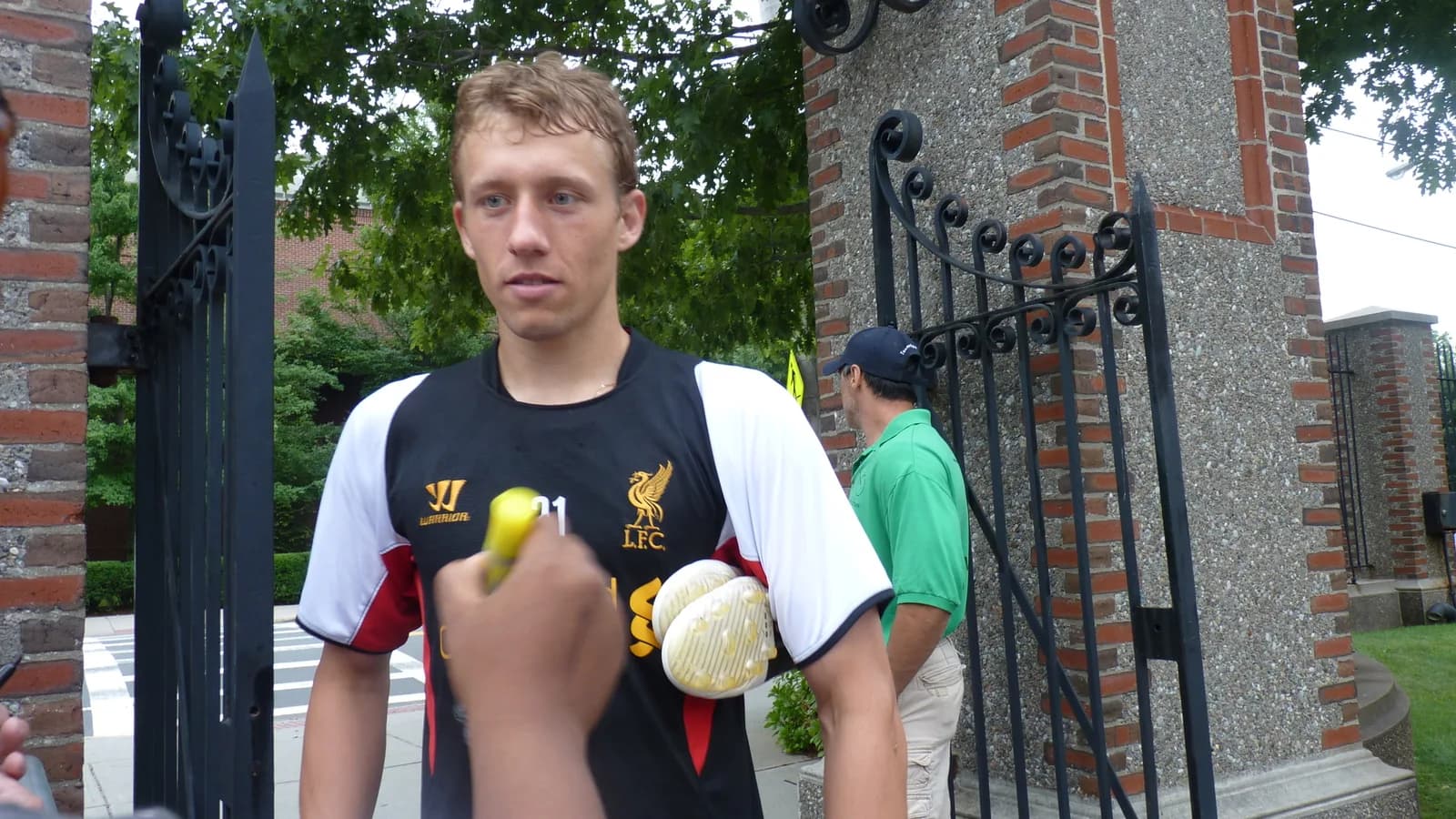 Lucas Leiva, com uniforme do Liverpool, assina autógrafo para torcedores