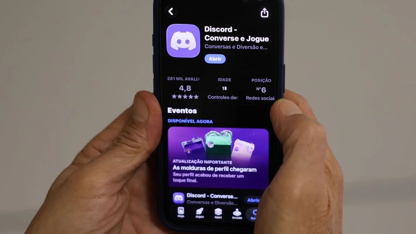 Mãos seguram um smartphone que exibe a página do aplicativo Discord na loja de aplicativos