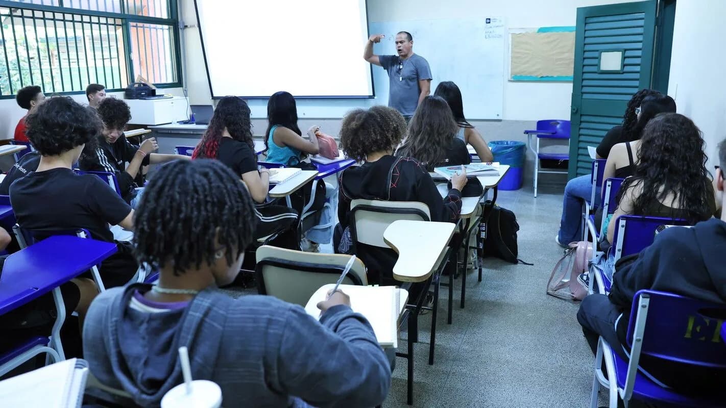 Professor dá aula para turma de estudantes em sala de aula de escola pública