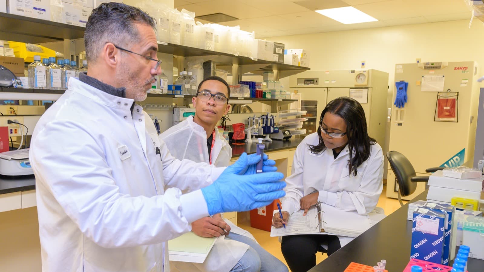 Cientistas de jaleco branco analisam frasco em laboratório de produção de vacinas de mRNA, foto de arquivo