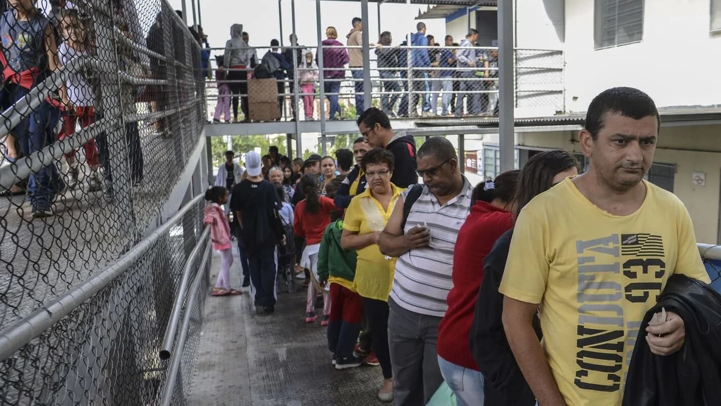 Fila de pessoas em corredor de unidade pública de saúde