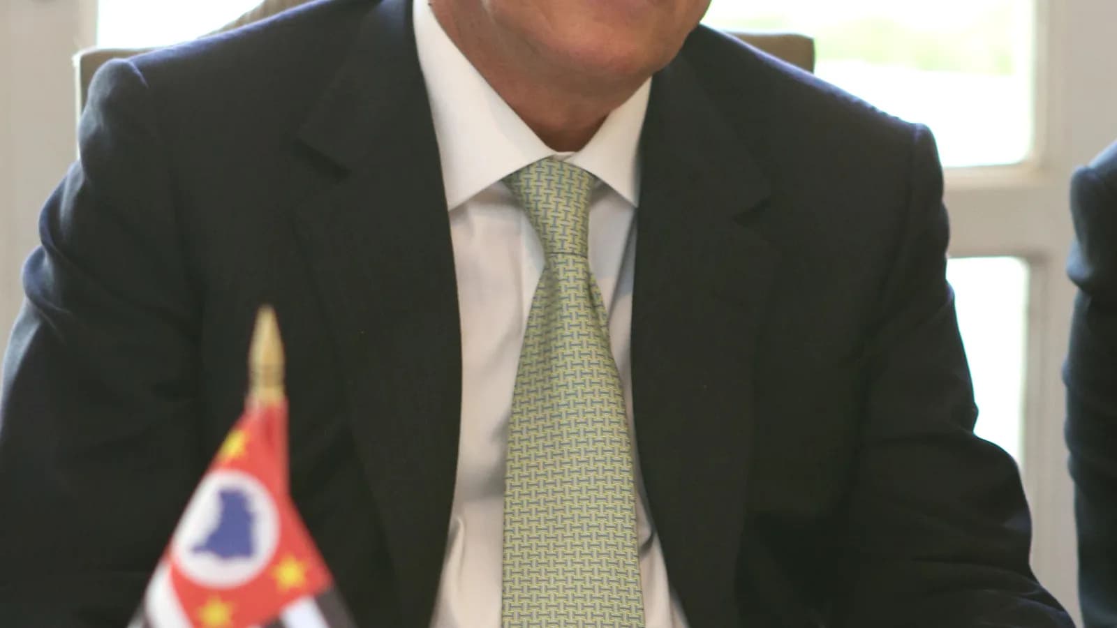 O vice-presidente Geraldo Alckmin em reunião de trabalho com a bandeira de São Paulo ao fundo