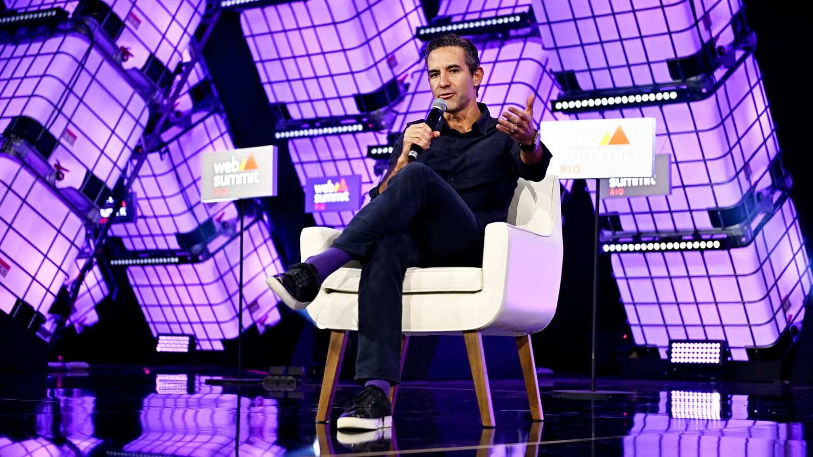 David Vélez, fundador do Nubank, sentado no palco durante evento da Web Summit Rio