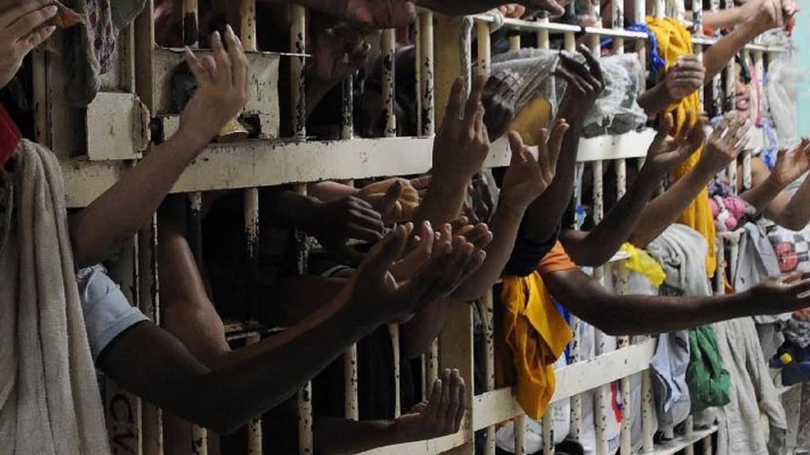 Mãos de detentos entre as grades de uma cela superlotada em presídio brasileiro (imagem de arquivo, não é do Complexo de Gericinó)
