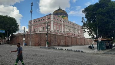 Fachada do Teatro Amazonas, em Manaus, com pedestre passando em frente
