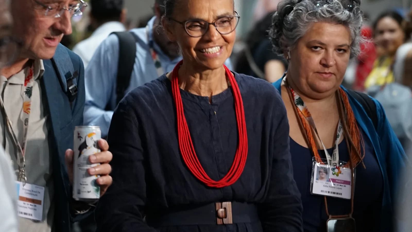 Marina Silva caminha em meio a outras pessoas durante evento na COP30