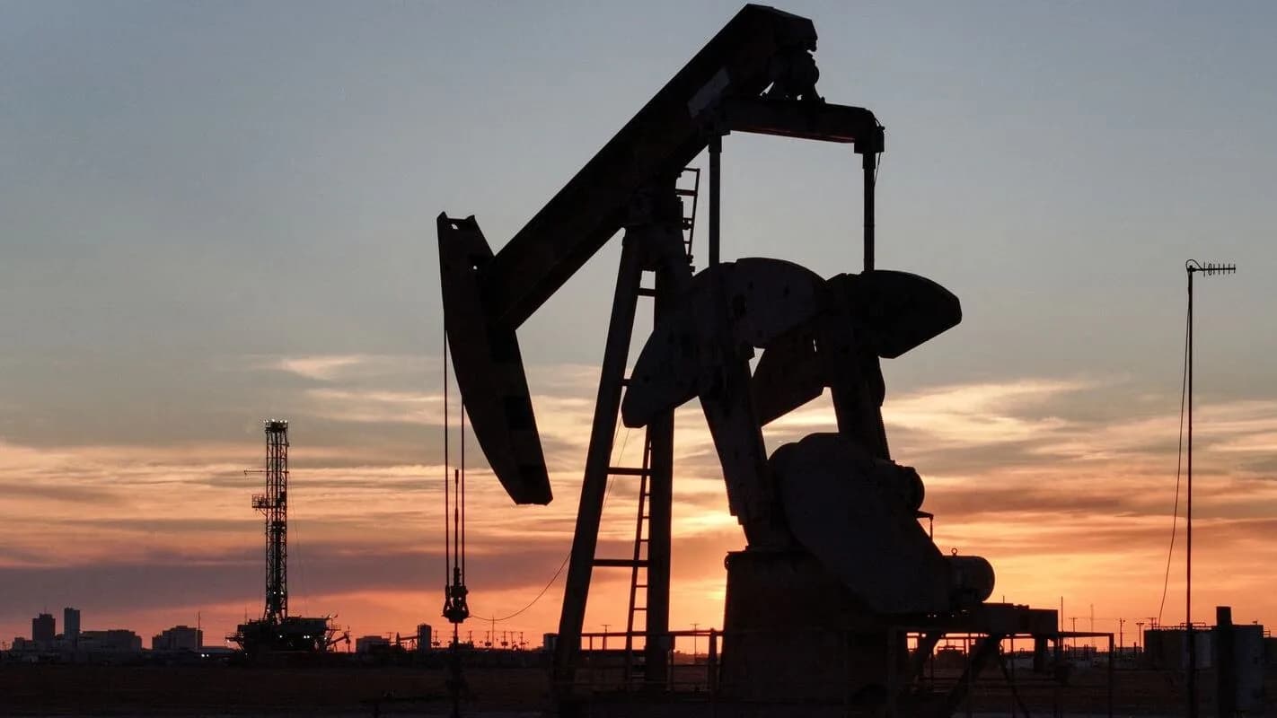 Silhueta de bomba de extração de petróleo contra o pôr do sol