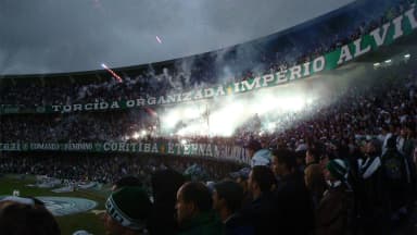 Torcida organizada do Coritiba com sinalizadores acesos nas arquibancadas do Couto Pereira
