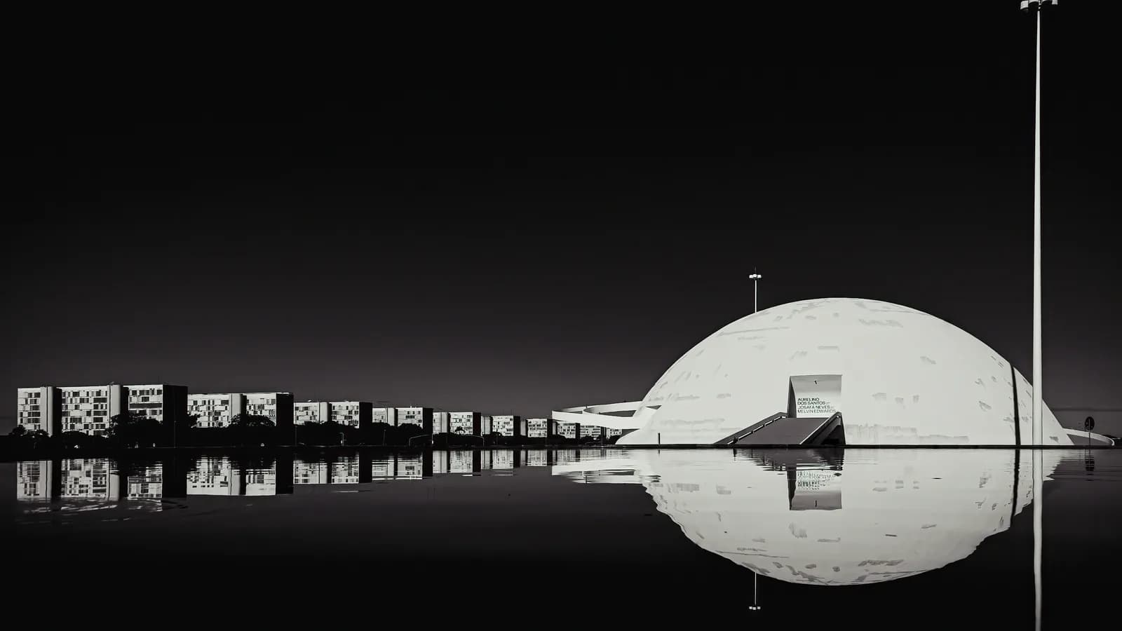 Vista noturna do Museu Nacional da República, em Brasília, refletido na água
