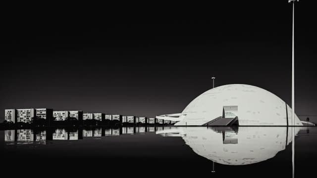 Vista noturna do Museu Nacional da República, em Brasília, refletido na água